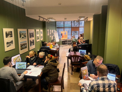 sala z osobami siedzącymi przy stolikach z koputerami, rozmowy o wnioskach do BO