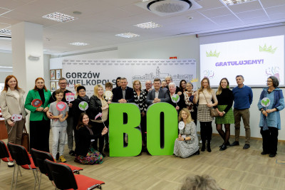 grupa osób pozuje prz literach przestrzennych BO