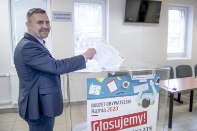Burmistrz Michał Pasieczny, wrzucający papierowy głos do urny.